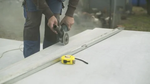 Builder cutting off sheet of slate with angle grinder. Video stock 247523594
