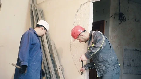 The Builder destroys the plaster on the wall Stock Footage 99787896