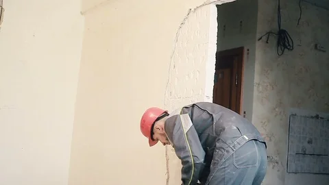 The Builder destroys the plaster on the wall Stock Footage 99788869