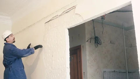 The Builder destroys the plaster on the wall Stock Footage 99789512