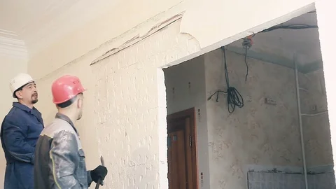 The Builder destroys the plaster on the wall Stock Footage 99789582