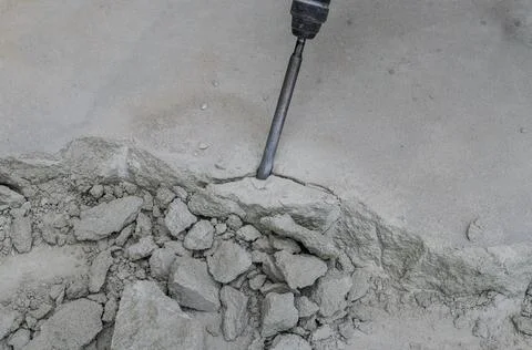 A builder dismantles a perforator drill breaks the concrete floor at a construct Stock Photos