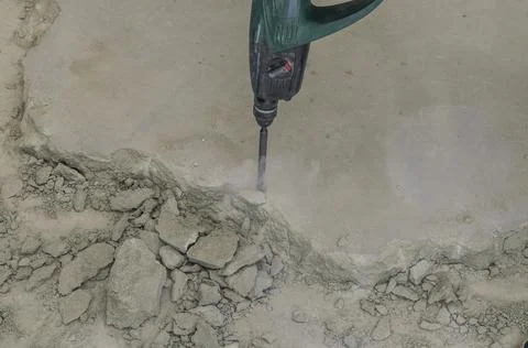 A builder dismantles a perforator drill breaks the concrete floor at a construct Stock Photos