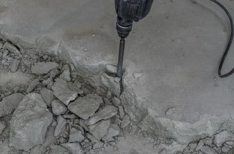 A builder dismantles a perforator drill breaks the concrete floor at a construct Stock Photos