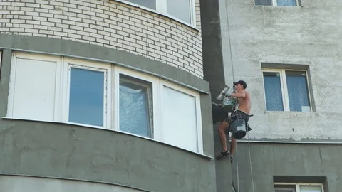 Builder doing insulating work holding on insurance at height Video stock 114760037