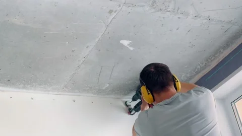 The builder is doing one of the types of construction work. With a drill with a Stock Footage 154338728