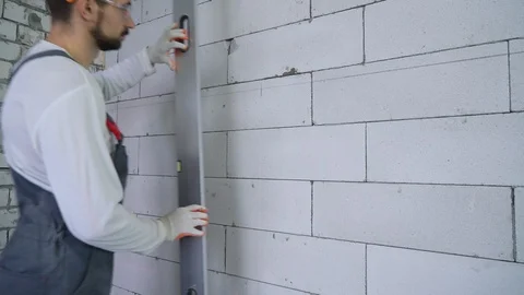 Builder drawing a line on wall according to laser beam level Stock Footage 106125773