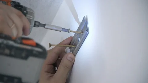 A Builder drills a hole in the wall Stock Footage 103949652
