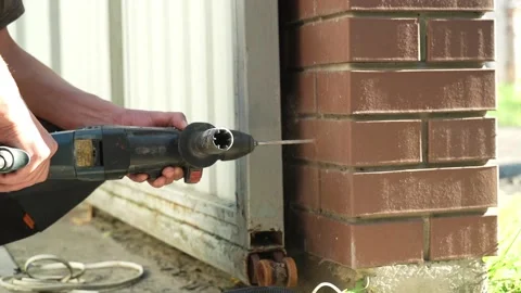 Builder Drills a hole in the wall with a Hammer Drill Stock Footage 258645978