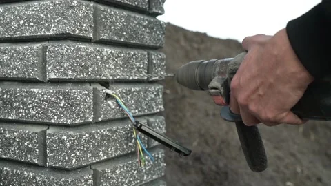 Builder Drills a hole in the wall with a Hammer Drill Stock Footage 259037432