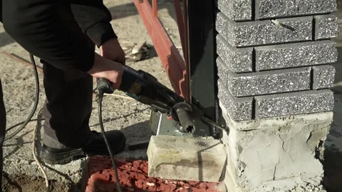 Builder Drills a hole in the wall with a Hammer Drill Stock Footage 259037438