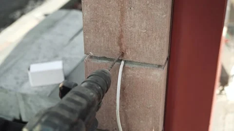Builder Drills a hole in the wall with a Hammer Drill Stock Footage 263294786