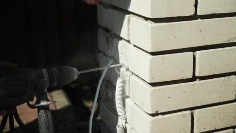 Builder Drills a hole in the wall with a Hammer Drill Stock Footage 274530453