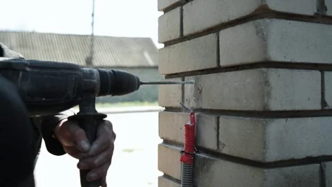 Builder Drills a hole in the wall with a Hammer Drill Stock Footage 274530457