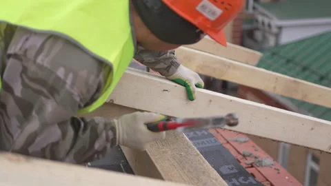 Builder drives nail into thick timber beam with force Видео 311892770