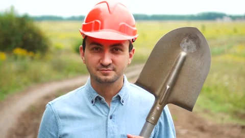 Builder, engineer or road worker is holding a shovel and looking at camera Stock Footage 137442209