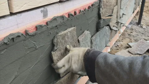 Builder faces the basement of a house with a wild stone. Flat for cladding Video stock 239265529