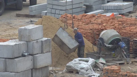Builder fastens a container for cement on cables of a construction crane Video stock 120674200