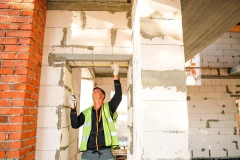 Builder fastens joint, installs support, checks wall frame setup, site acti.. Stock Photos