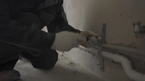 The builder fastens the pipe to the wall Stock Footage 101664010
