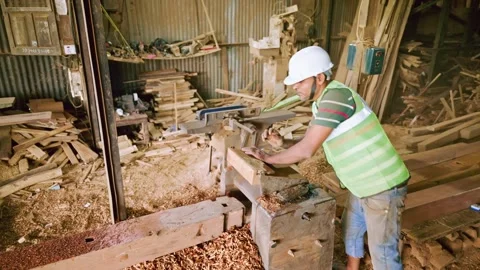 Builder feeds panel into cutter at busy workspace Stock Footage 310717855