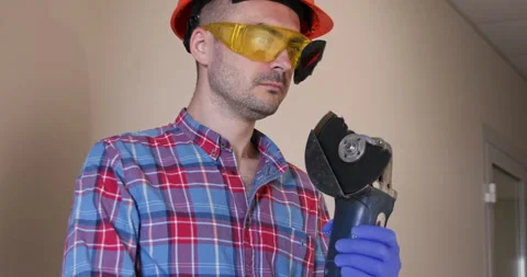 Builder feeling jolt as part of disk wedged into glasses removed goggles Stockbeeldmateriaal 258071339