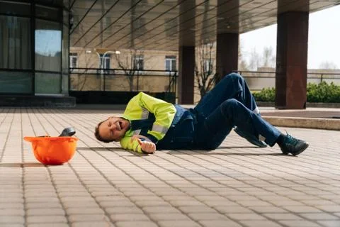 The builder fell from the construction site, broke his arm. industrial accide Stock Photos