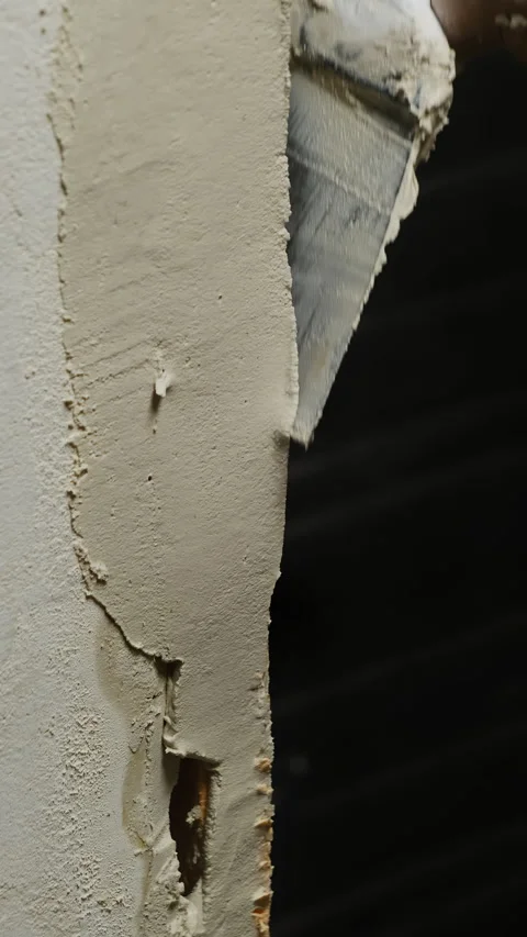 Builder fills small gaps and imperfections on wall Stock Footage 317083432
