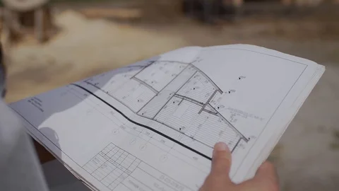 Builder foreman looking at the paper house project at the construction site Stock Footage 126707942