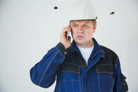 Builder foreman in a white helmet at a construction site indoors Stock Photos