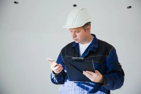 Builder foreman in a white helmet at a construction site indoors Stock Photos
