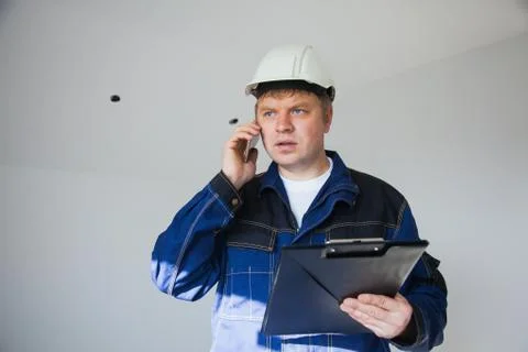 Builder foreman in a white helmet at a construction site indoors 库存照片