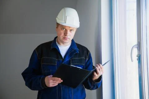 Builder foreman in a white helmet at a construction site indoors 库存照片