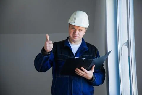 Builder foreman in a white helmet at a construction site indoors 库存照片