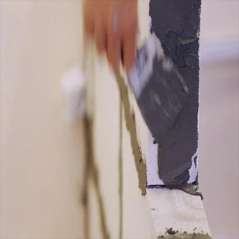 A builder gets the grout on the wall of foam concrete bricks, close-up Stock Footage 69460206