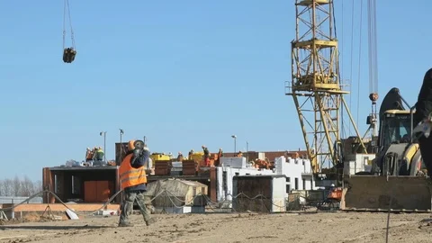 Builder goes to the background construction site Stock Footage