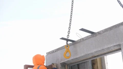 Builder goes up ladder to hook concrete panel to suspension Stock Footage 124892279