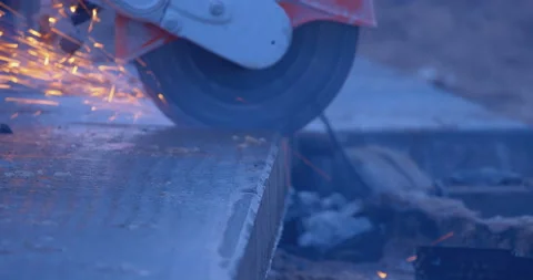 A builder by grinder cuts off part of a thick slab, a lot of sparks and smoke Stock Footage 147614138