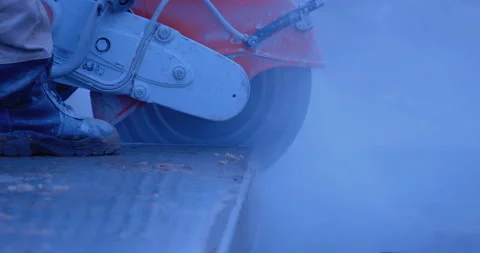 A builder by grinder cuts off part of a thick slab, a lot of sparks and smoke Stock Footage 147618109