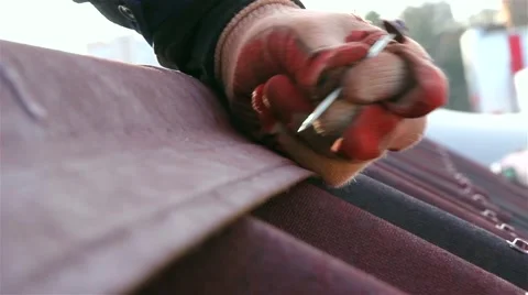 Builder hammering a nail, Mount installs a red roof with shingles. Close-up Stock Footage 47847539
