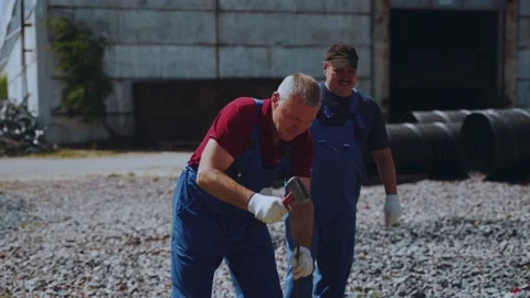 A builder hammers a metal rod with a hammer Stock Footage 201031395