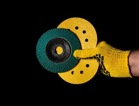 Builder hand in yellow glove keeps or gives abrasive tools close up Stock Photos