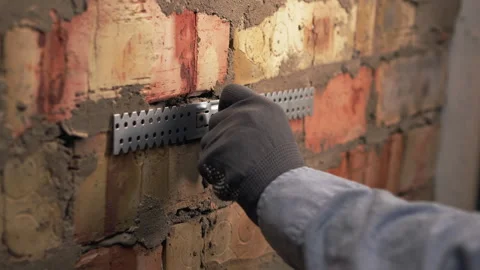 Builder hands fixing drywall profile bracket with drill Stock Footage 330359411