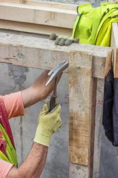 Builder hands hammering a nail into a plank Stock Photos