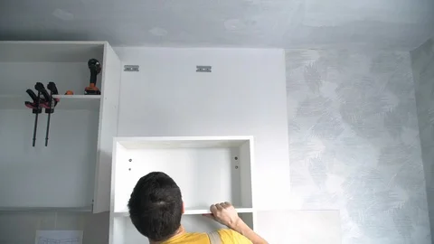Builder hang a wall Cabinet Stock Footage 103949097