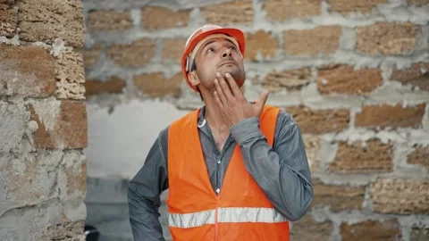 Builder in hardhat standing at construction site Stock Footage 256080327