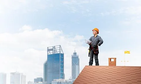 Builder in hardhat with technical blueprints Stock Photos