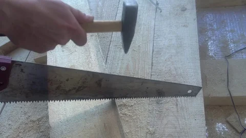 The Builder has a hammer on the hacksaw,an example of how not to work Stock Footage 75912165