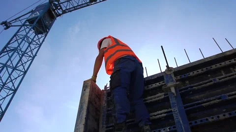 Builder in helmet hammers on a construction Stock Footage 242590509