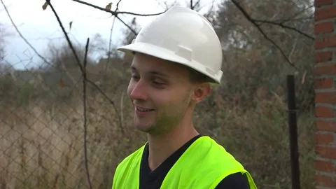 Builder in a helmet smiles Stock Footage 75619022